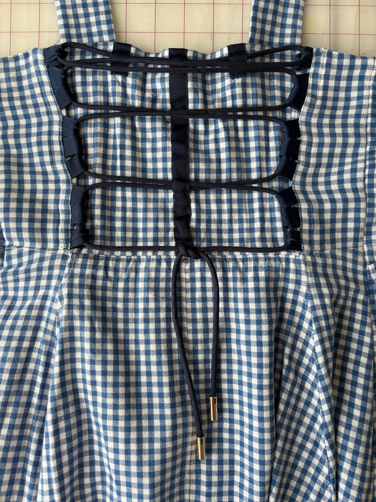 sy snörning i ryggen på en klänning